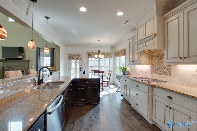 kitchen featuring ornamental molding, appliances with stainless steel finishes, a sink, and visible vents