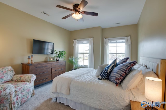 bedroom featuring ceiling fan, visible vents, and light colored carpet