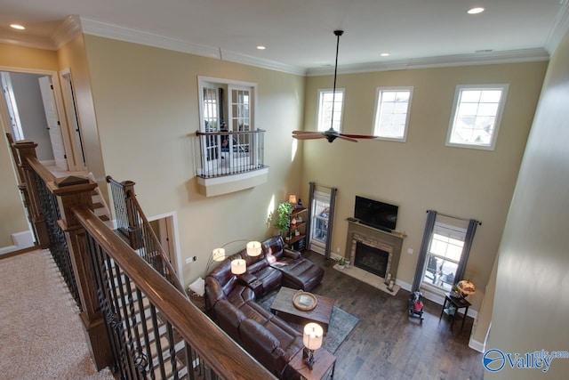 living room with a fireplace with flush hearth, a healthy amount of sunlight, and ornamental molding