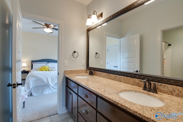 full bathroom with double vanity, ceiling fan, connected bathroom, and a sink