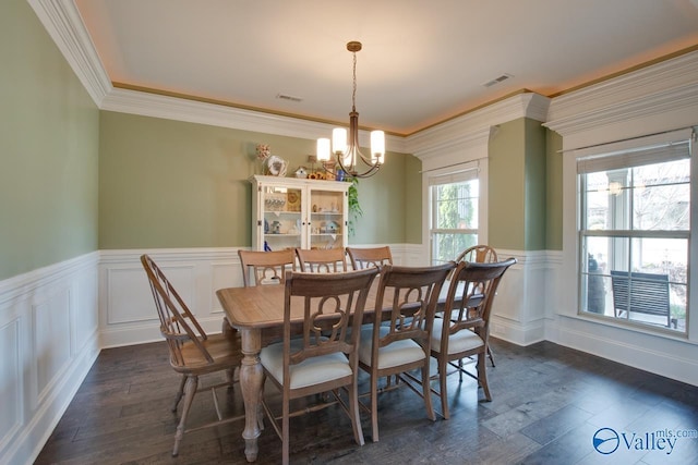 dining room with dark wood-style flooring, wainscoting, visible vents, and a notable chandelier