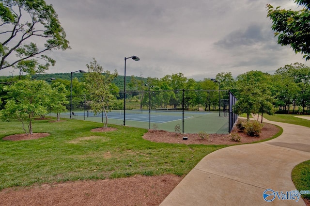 view of sport court with a yard and fence