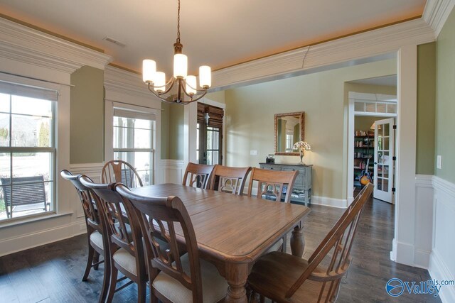 dining area featuring visible vents, a decorative wall, dark wood-style flooring, and ornamental molding