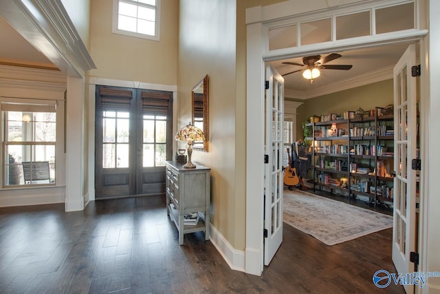 foyer featuring baseboards, a ceiling fan, dark wood-style flooring, crown molding, and french doors