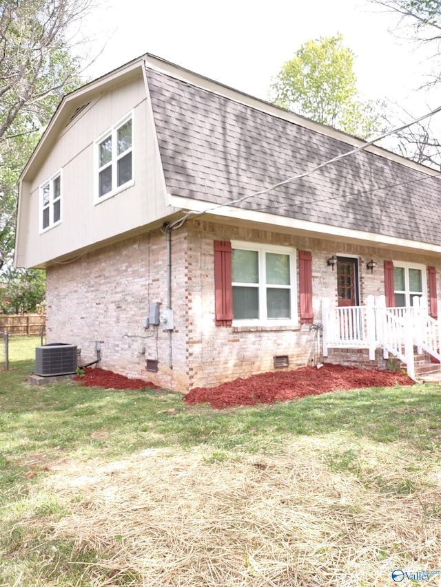 view of front of house featuring brick siding, a shingled roof, crawl space, and central AC