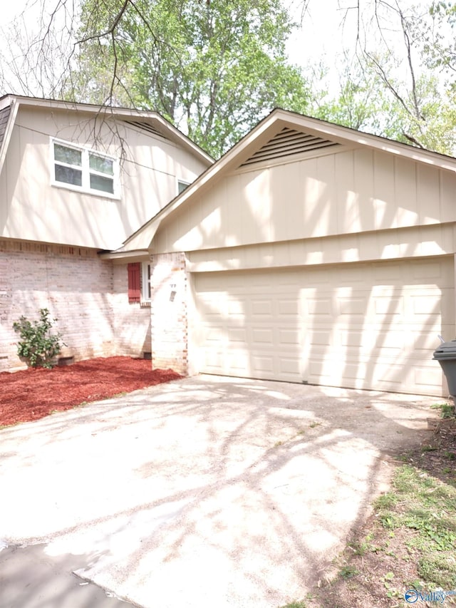 view of front facade with brick siding, driveway, and a garage