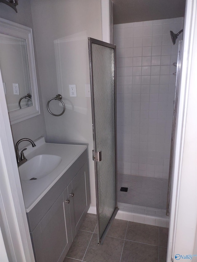 full bath with a stall shower, vanity, and tile patterned flooring