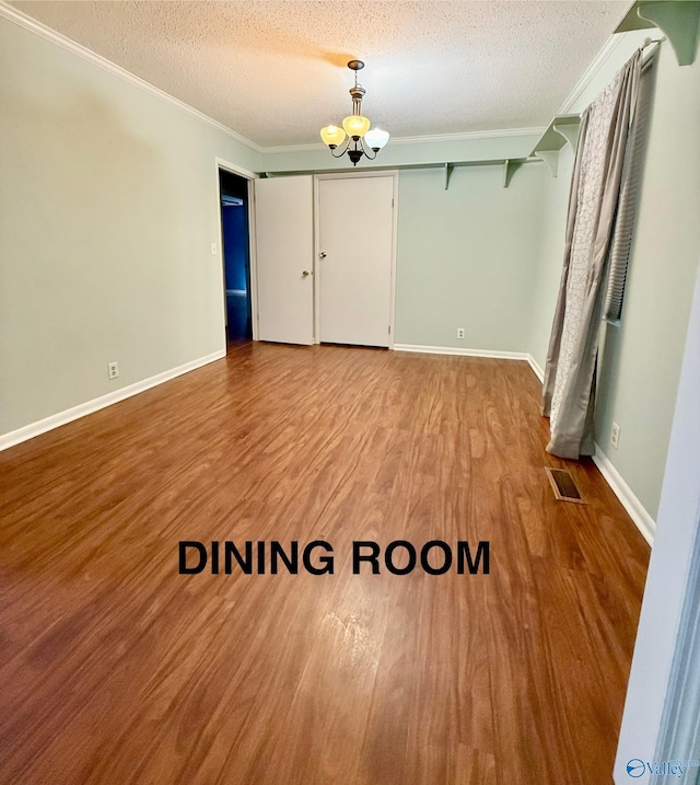 unfurnished bedroom featuring a chandelier, a textured ceiling, light wood-type flooring, ornamental molding, and a closet