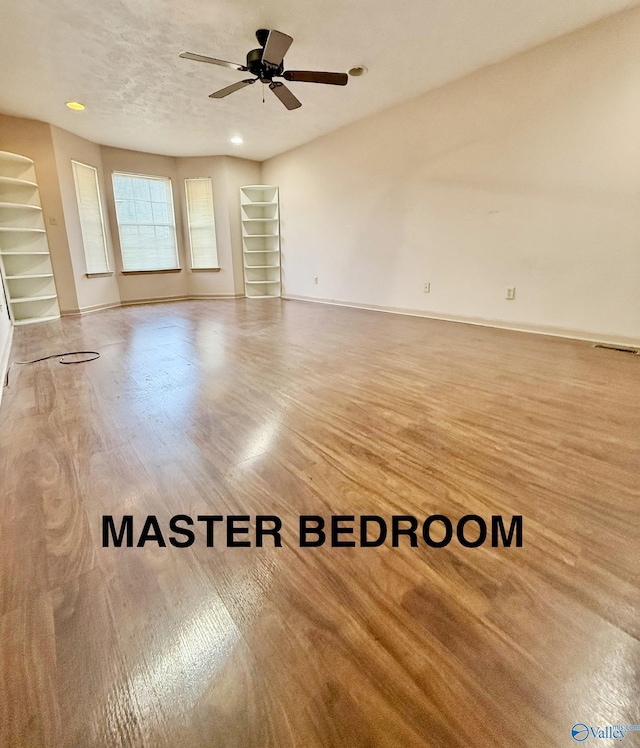 spare room featuring hardwood / wood-style flooring, a textured ceiling, and ceiling fan