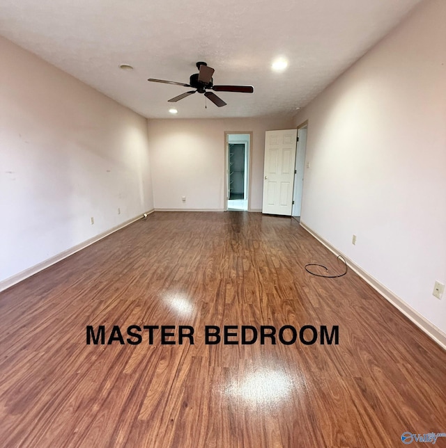 spare room with ceiling fan and dark hardwood / wood-style flooring