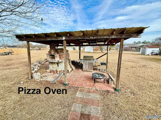 view of patio featuring grilling area, a fireplace, and an outdoor fire pit