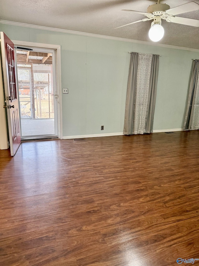 empty room featuring crown molding, dark hardwood / wood-style floors, ceiling fan, and a textured ceiling