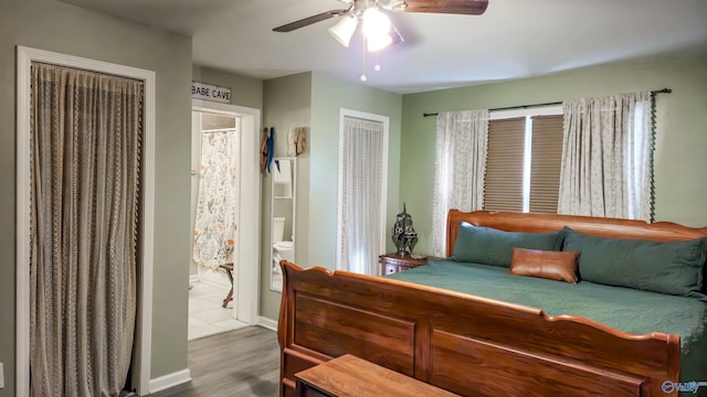 bedroom with ceiling fan, wood-type flooring, and ensuite bath