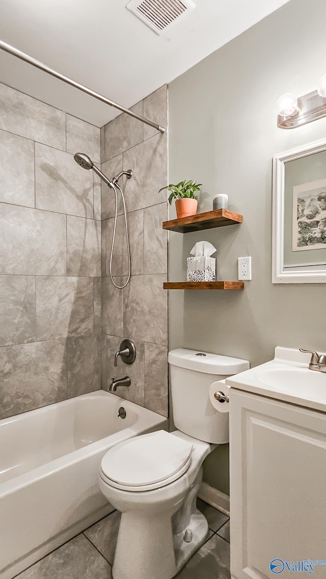 full bathroom featuring tile patterned floors, tiled shower / bath combo, toilet, and vanity