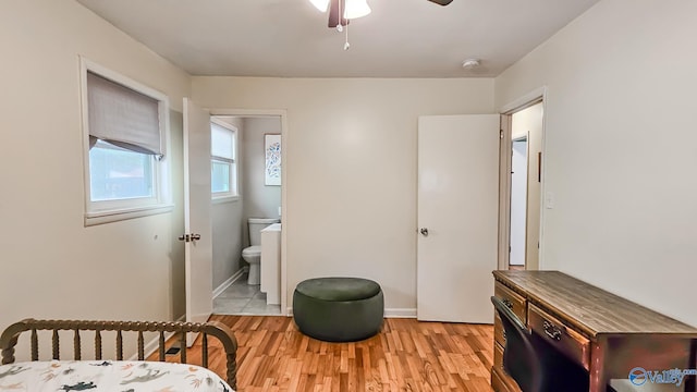 bedroom featuring ceiling fan, connected bathroom, and light hardwood / wood-style flooring