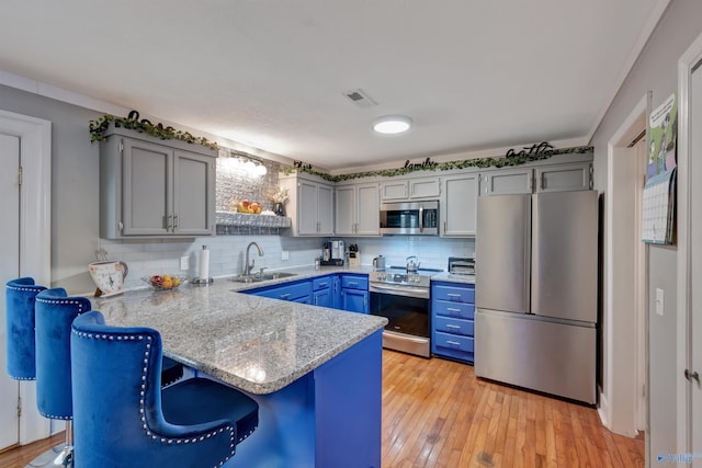 kitchen featuring stainless steel appliances, kitchen peninsula, tasteful backsplash, and sink