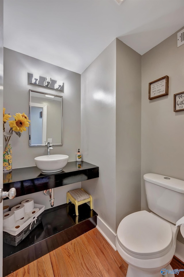 bathroom featuring toilet, sink, and hardwood / wood-style flooring