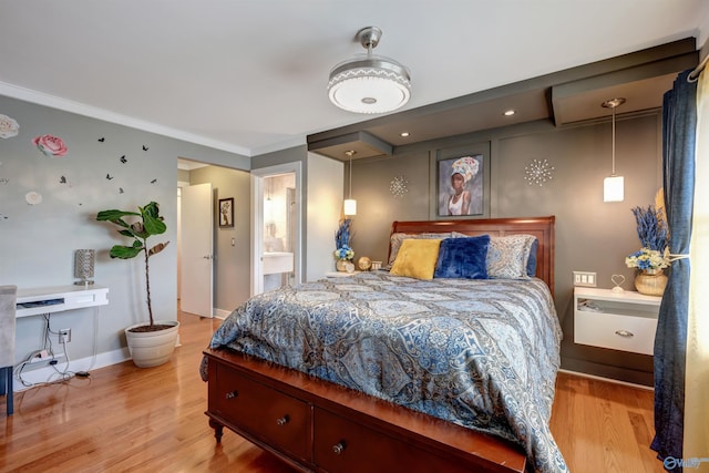 bedroom with ensuite bathroom, light wood-type flooring, and crown molding