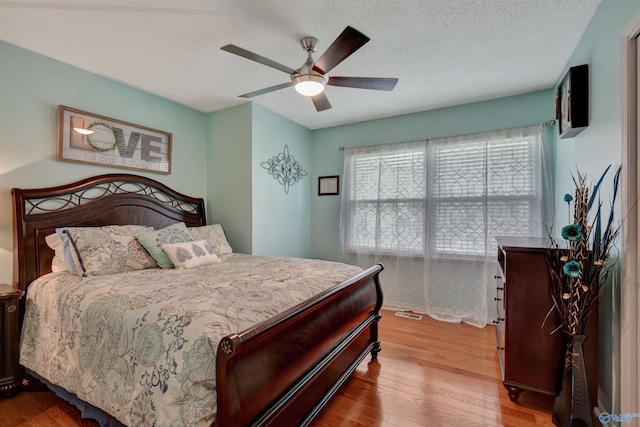 bedroom featuring ceiling fan, a textured ceiling, and hardwood / wood-style flooring