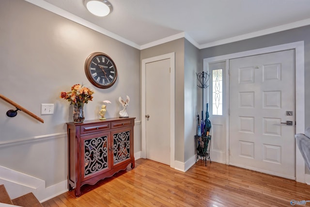 foyer entrance with light hardwood / wood-style flooring and ornamental molding