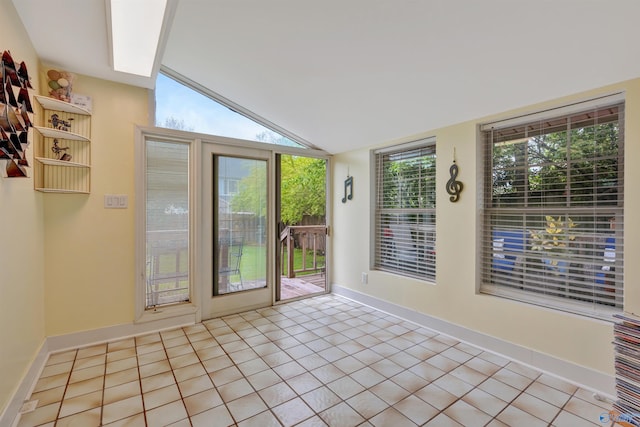 doorway featuring light tile patterned floors and lofted ceiling