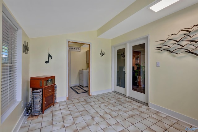 interior space featuring light tile patterned floors, lofted ceiling, and washer / clothes dryer