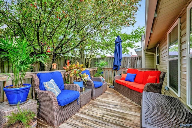 wooden terrace with an outdoor living space