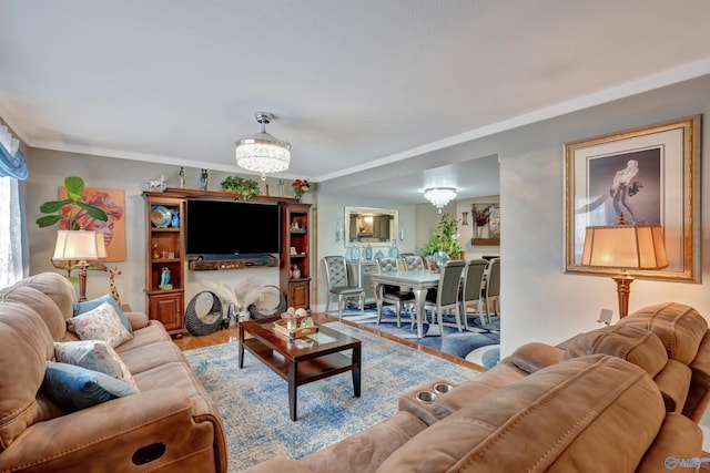 living room featuring crown molding, a chandelier, and hardwood / wood-style floors