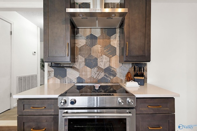 kitchen with tasteful backsplash, stainless steel range with electric cooktop, visible vents, dark brown cabinetry, and ventilation hood