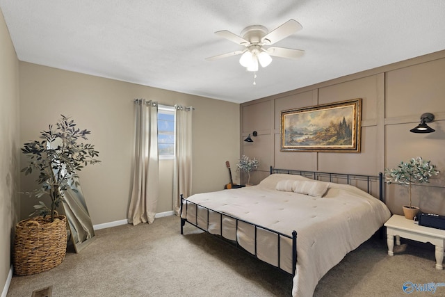 bedroom featuring baseboards, a textured ceiling, visible vents, a ceiling fan, and light carpet