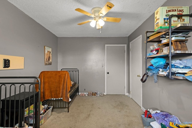 carpeted bedroom with a ceiling fan and a textured ceiling