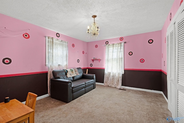 interior space featuring baseboards, a chandelier, a textured ceiling, carpet floors, and a closet