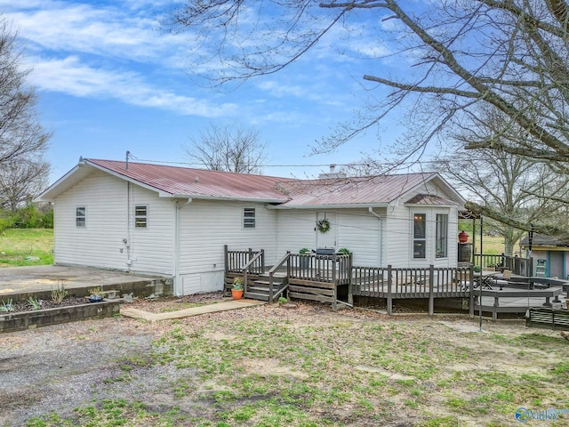 back of property with metal roof and a deck