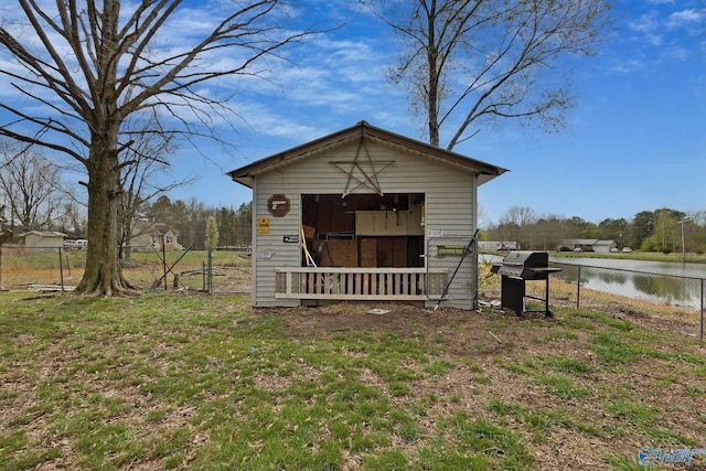 view of shed with a water view and fence