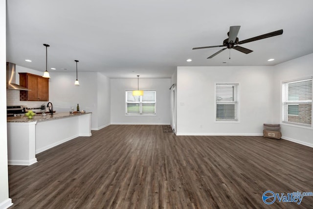 unfurnished living room featuring dark hardwood / wood-style floors, ceiling fan, and sink