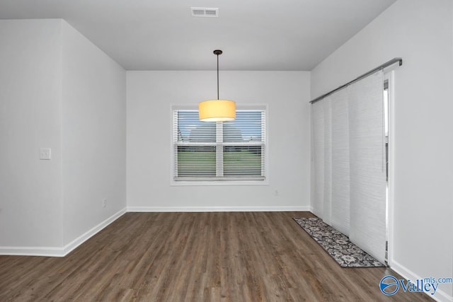 unfurnished dining area with dark wood-type flooring