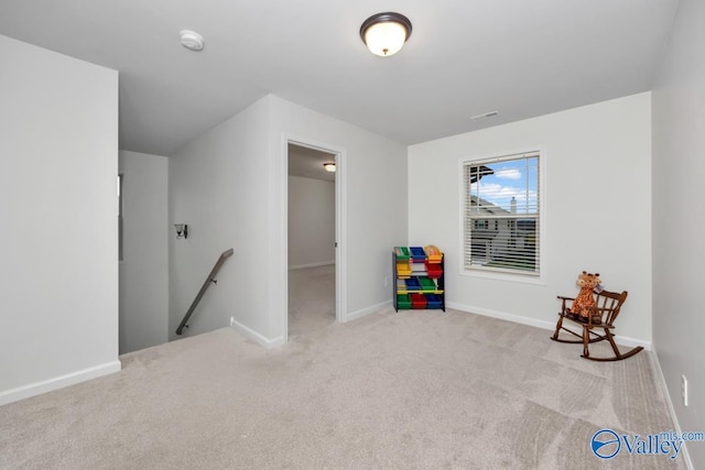 recreation room with light colored carpet