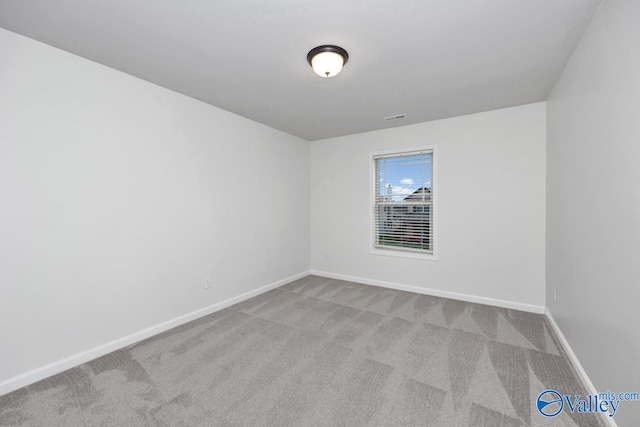 spare room featuring light colored carpet