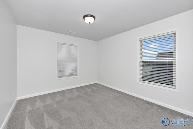 unfurnished room featuring light carpet