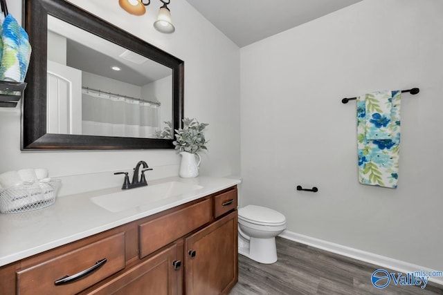 bathroom with vanity, hardwood / wood-style flooring, and toilet