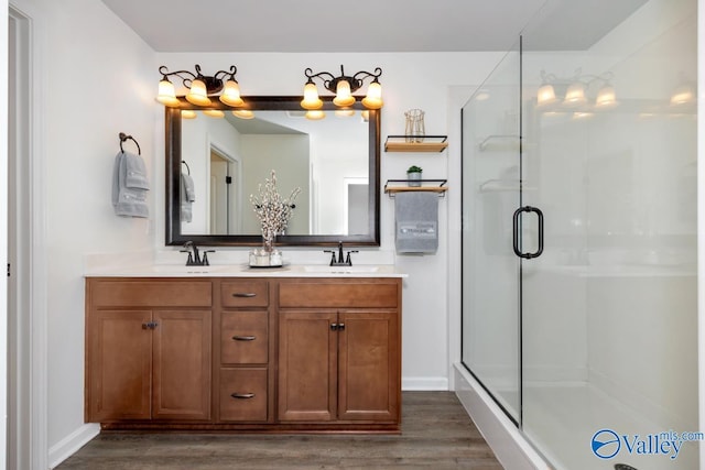 bathroom featuring hardwood / wood-style floors, vanity, and a shower with shower door