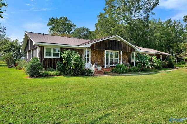 ranch-style home with covered porch and a front lawn