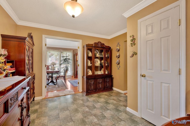 foyer featuring a textured ceiling, light tile patterned floors, and ornamental molding