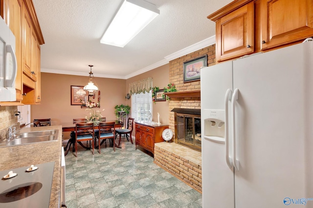 kitchen featuring a fireplace, white appliances, ornamental molding, sink, and light tile patterned floors