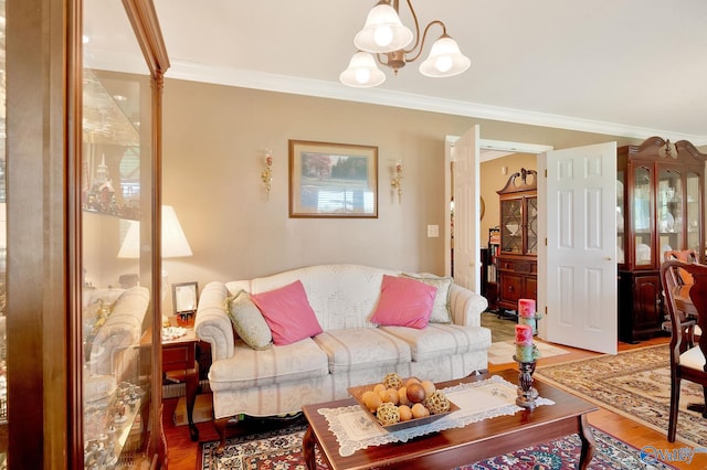 living room featuring wood-type flooring, a notable chandelier, and ornamental molding