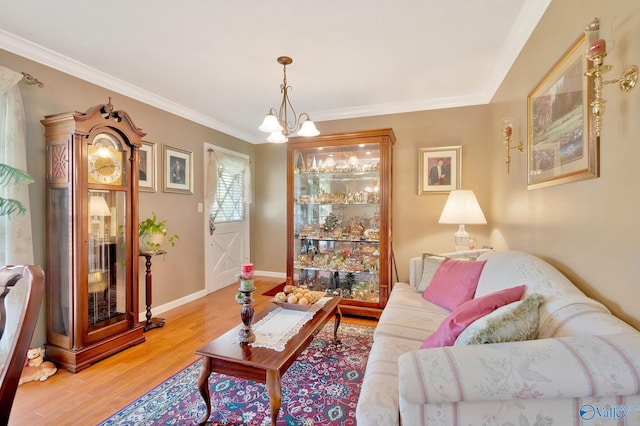 living room featuring light hardwood / wood-style floors, an inviting chandelier, and crown molding
