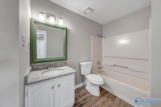 full bathroom with vanity, wood-type flooring, a textured ceiling, and  shower combination