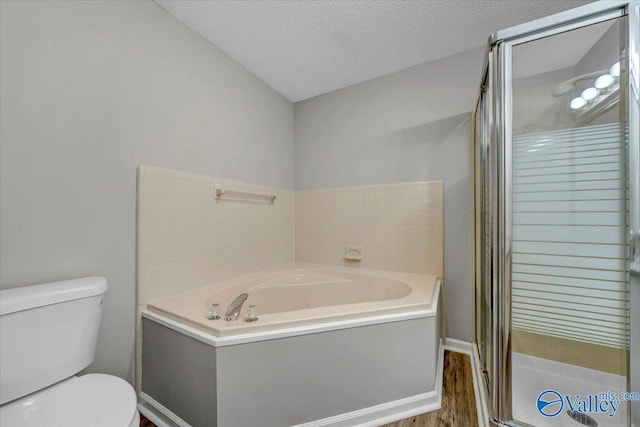 bathroom with plus walk in shower, hardwood / wood-style floors, a textured ceiling, and toilet