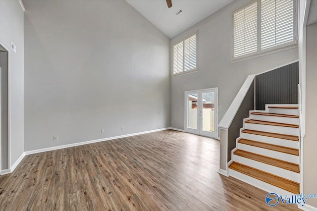 foyer with hardwood / wood-style floors, high vaulted ceiling, and french doors