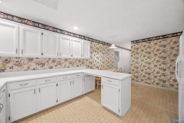 kitchen with kitchen peninsula, white cabinets, and decorative light fixtures